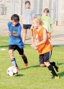 Efrain Diaz, 13, and Stokes Moore, 11, battle for the ball during a drill at Thursday’s camp.|Justin Schuver