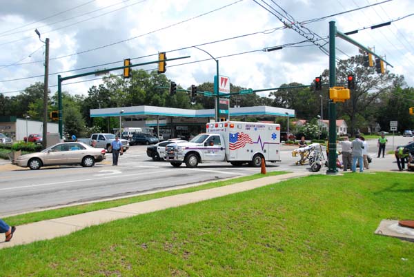 Decatur County Emergency Medical Service personnel and Bainbridge Public Safety officers tend to two people who were injured when their motorcycle was struck by a car at the intersection of Shotwell Street and Sims Street on Friday afternoon.