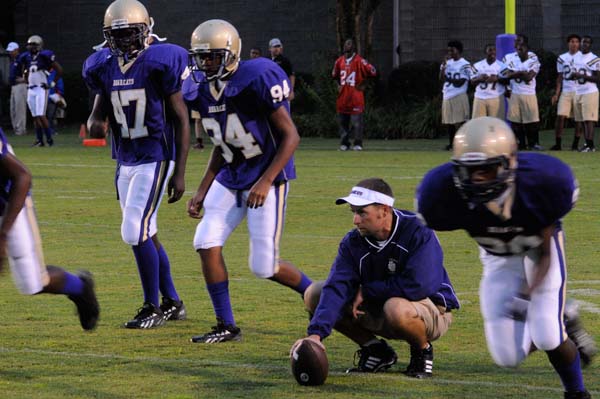 BHS wide receivers coach Marcus Singletary watches his players go through a pre-game warmup before last Friday night's game.