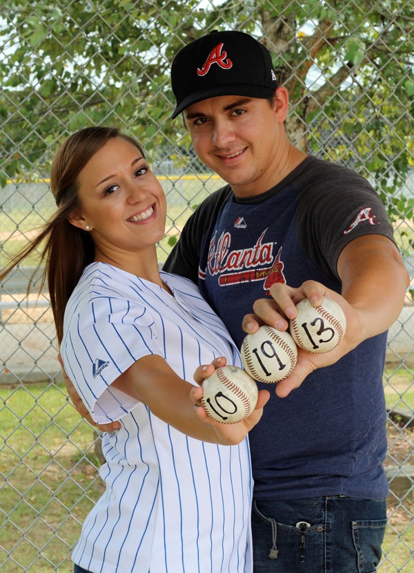 Balla and Brock hold baseballs showing their wedding date which is set for October 19. 