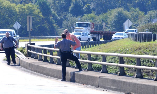Police communicate with a man who was attempting to jump off of the Marvin Griffin Bypass at noon Monday. -- Ashley Johnson