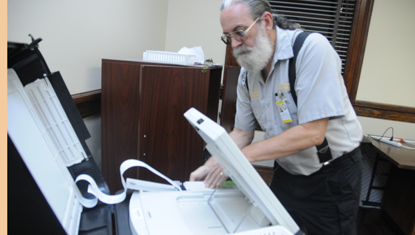 County computer technician Roy Reynolds runs the ballot numbers through a machine at the courthouse Tuesday night, after all precincts reported in.