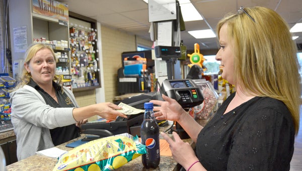 Lisa Haire, right,  buys a $1 ticket for the Mega Millions Jackpot at Southwind Truck Stop just to try her luck at the $636 million prize. 