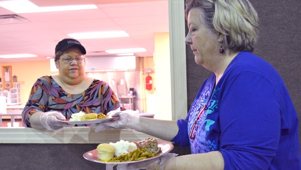 Volunteers Deborah Watts and Kit Griffin serve plates of food Thursday at the Bainbridge Soup Kitchen. The ministry has now been in operation at Bainbridge Church of God for one year. 