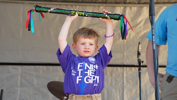 Four-year-old Knox Bridges raises the Relay for Life spirit stick above his head in front of a crowd Saturday at Bainbridge Middle School.