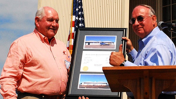 Friends former Governor Sonny Perdue and Alec Poitevint show a plaque thanking them for their work on the historic WWII airplane hangar at the airport. The project has completed several phases and a crowd gathered Saturday for the official dedication. 