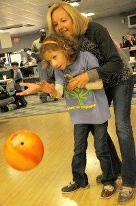 The fast lane: Lindsey Hiers and her mother, Krystal, toss a bowling ball down the lane during the Special Olympics bowling event Thursday.