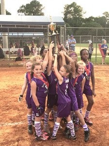 The girls smile as they hold up their trophy.