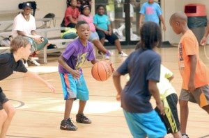 Camryn Scott searches for an open teammate during a practice game at the McCullough YMCA camp.