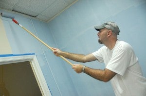United Way of Bainbridge board member Jeff Napier rolls “blissful blue” paint onto the wall in the children’s room at the Samaritan Counseling Center.