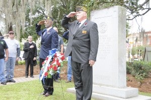 Post Commander John A. Marshall, left, and Commander Hill Yates salute the U.S. flag as Taps is played Wednesday morning at Willis Park. | Powell Cobb, Post-Searchlight